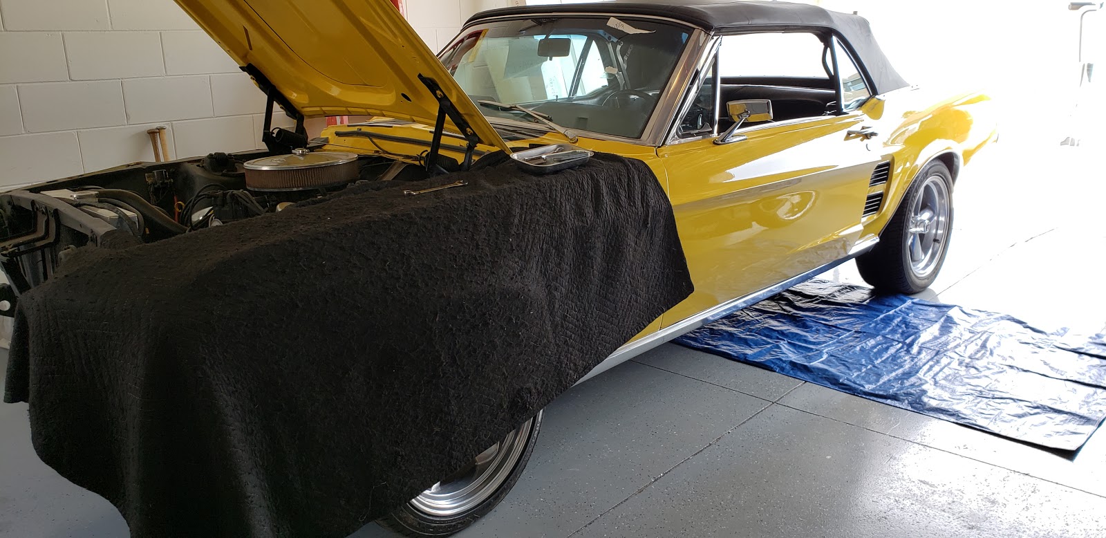 Classic yellow car receiving mobile mechanic service